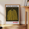 Yellow pumpkin with black polka dots in Yayoi Kusama's signature style - beside a round wooden side table with books