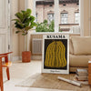 A pumpkin with polka dots in Yayoi Kusama's signature style, orange and black colors - in a Parisian living room with a sofa and a fig plant