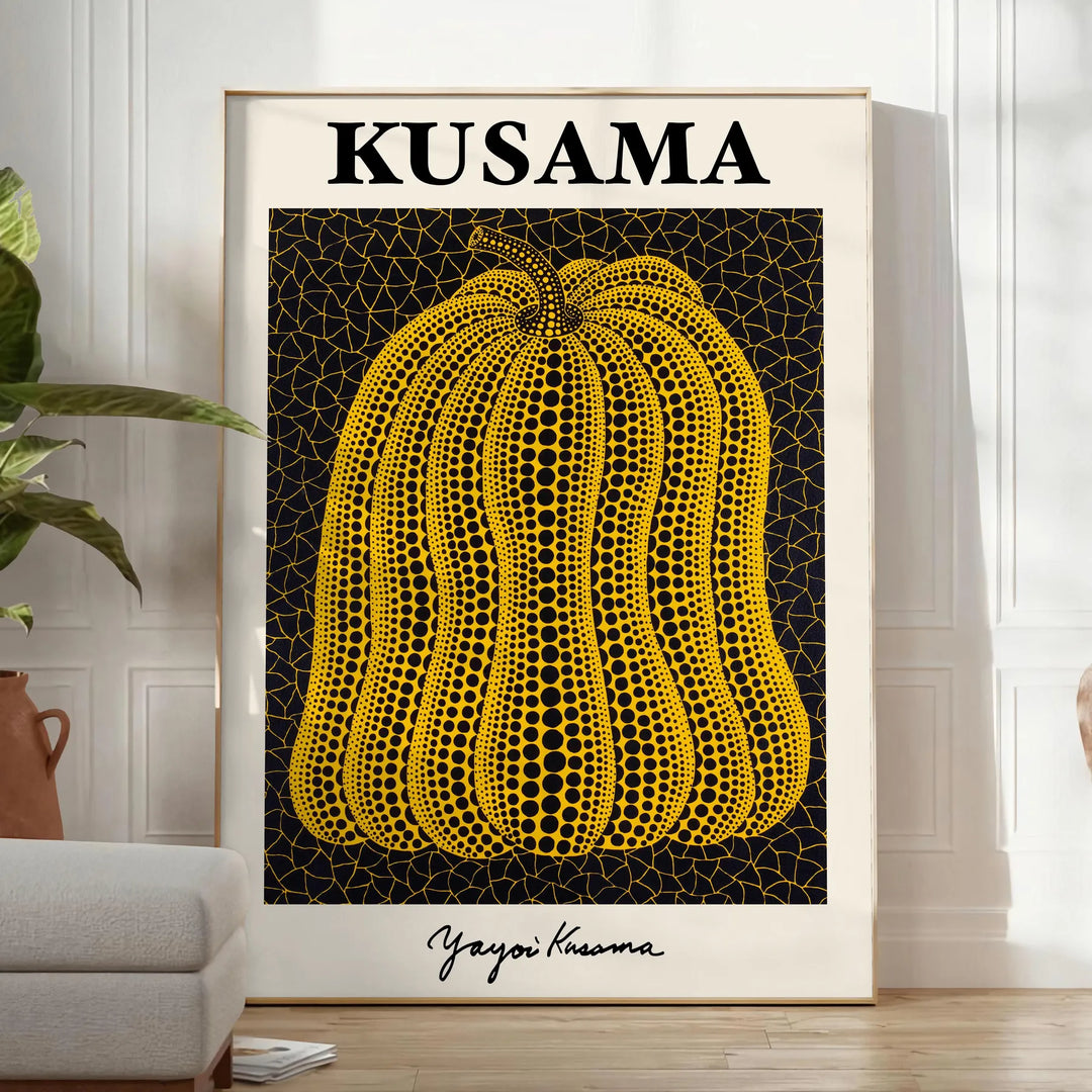 A pumpkin with polka dots in Yayoi Kusama's signature style, orange and black colors - in a bright minimalist room with a plant and an armchair