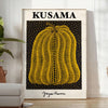 A pumpkin with polka dots in Yayoi Kusama's signature style, orange and black colors - in a bright minimalist room with a plant and an armchair