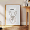 A rabbit in a serene gray and black color palette - beside a round wooden side table with books