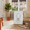 A rabbit in a serene gray and black color palette - in a Parisian living room with a sofa and a fig plant