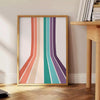 Design abstrato colorido apresentando um espectro de arco-íris em fundo cinza - ao lado de uma mesa de apoio redonda em madeira com livros