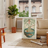 Illustration of a ramen bowl with chopsticks, featuring bold green and orange colors - in a Parisian living room with a sofa and a fig plant