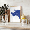 A rhinoceros standing in a natural habitat with blue and black tones - styled on a counter with eucalyptus and a bowl of lemons