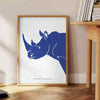 A rhinoceros standing in a natural habitat with blue and black tones - beside a round wooden side table with books