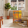 Illustration of San Francisco skyline with warm brown and orange tones - in a Parisian living room with a sofa and a fig plant
