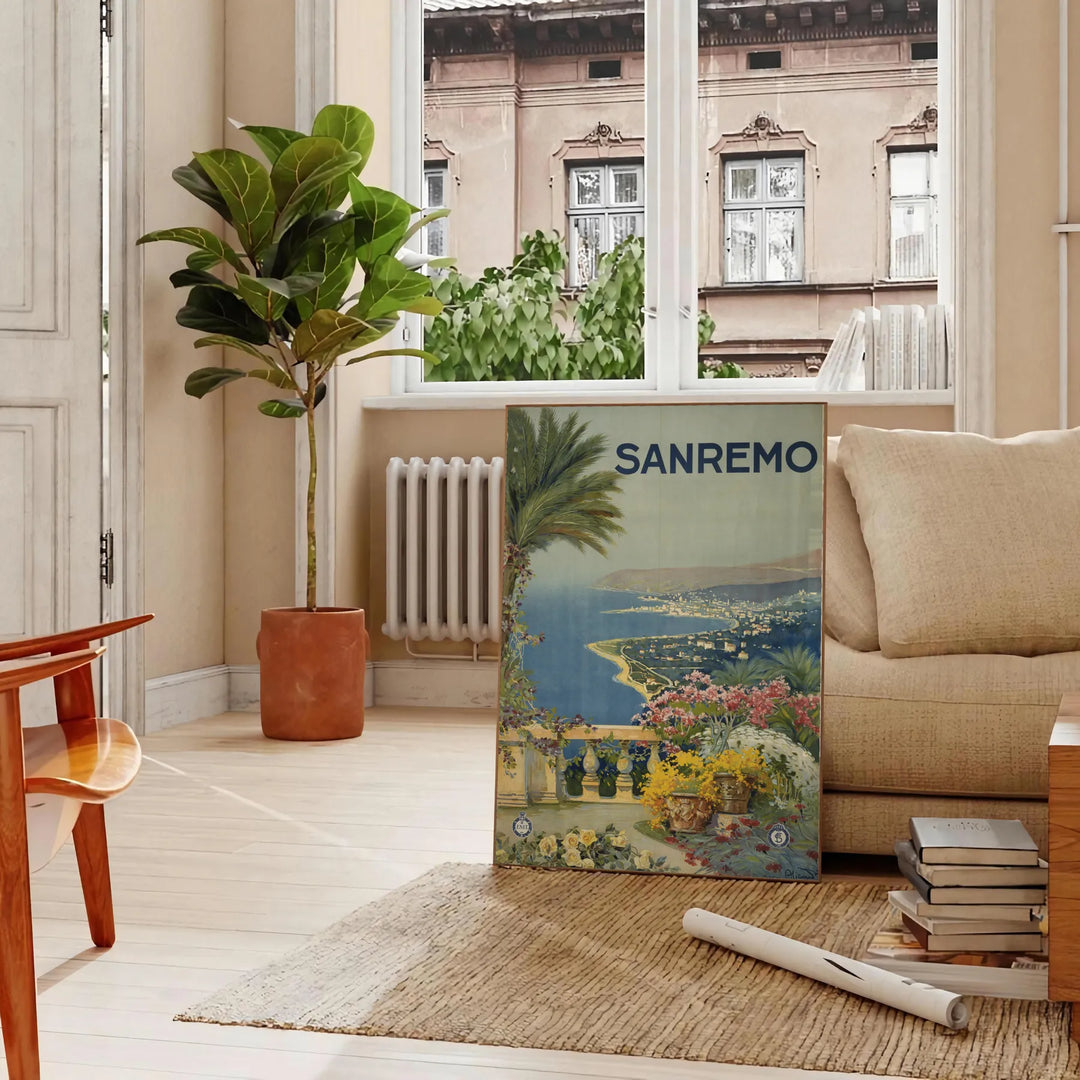 Travel poster depicting Sanremo, Italy, in soft gray and green tones - in a Parisian living room with a sofa and a fig plant