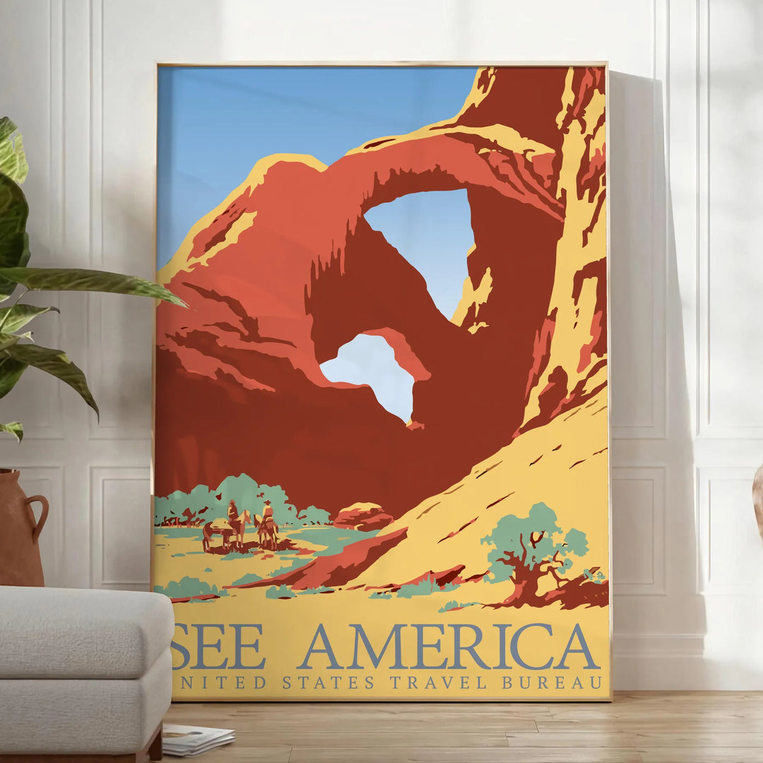 A retro travel poster featuring a yellow and blue landscape with mountains and a road - in a bright minimalist room with a plant and an armchair
