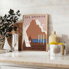 Vintage-style travel poster featuring the USA in muted gray and brown tones - styled on a counter with eucalyptus and a bowl of lemons