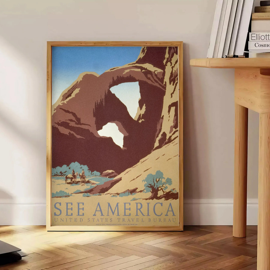 Travel poster featuring a serene landscape of America in gray and green tones - beside a round wooden side table with books