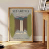 A vintage travel poster featuring the text 'See America' with green and gray landscapes. - beside a round wooden side table with books