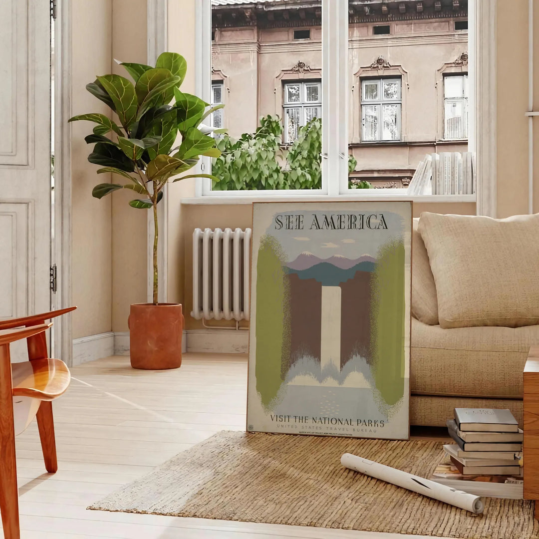 A vintage travel poster featuring the text 'See America' with green and gray landscapes. - in a Parisian living room with a sofa and a fig plant