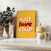 Abstract design featuring the phrase 'Self Love Club' in bold typography with warm orange and red tones - styled on a counter with eucalyptus and a bowl of lemons