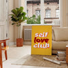 Abstract design featuring the phrase 'Self Love Club' in bold typography with warm orange and red tones - in a Parisian living room with a sofa and a fig plant