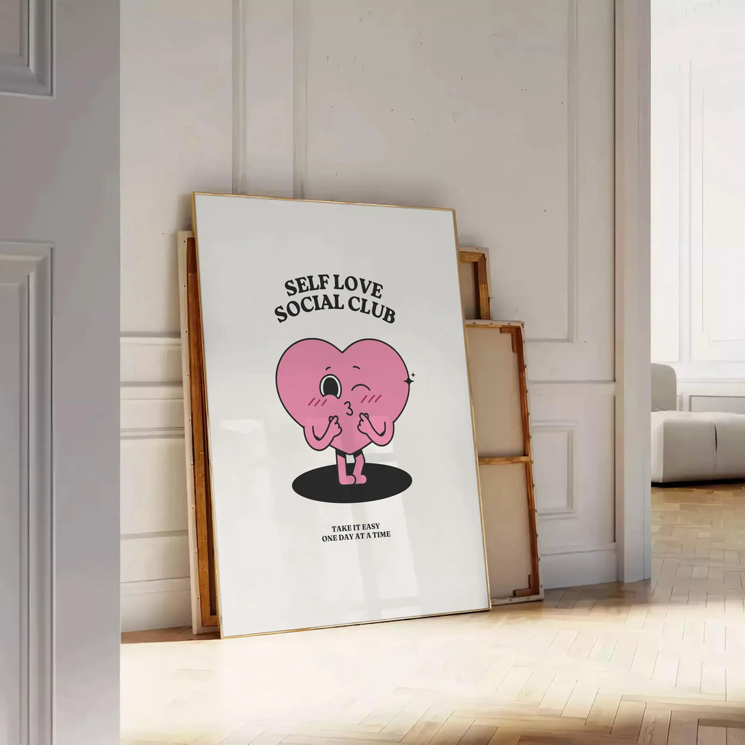 Minimalist poster featuring the phrase 'Self Love Social Club' in bold typography against a gray background - leaning on a herringbone floor against a white panelled wall