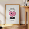 Minimalist poster featuring the phrase 'Self Love Social Club' in bold typography against a gray background - beside a round wooden side table with books