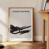 Abstract shapes in black and orange with a bohemian style - beside a round wooden side table with books