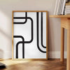 Abstract shapes in black and blue with a boho style - beside a round wooden side table with books
