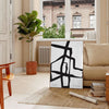 Abstract boho shapes in earthy tones with a textured background - in a Parisian living room with a sofa and a fig plant