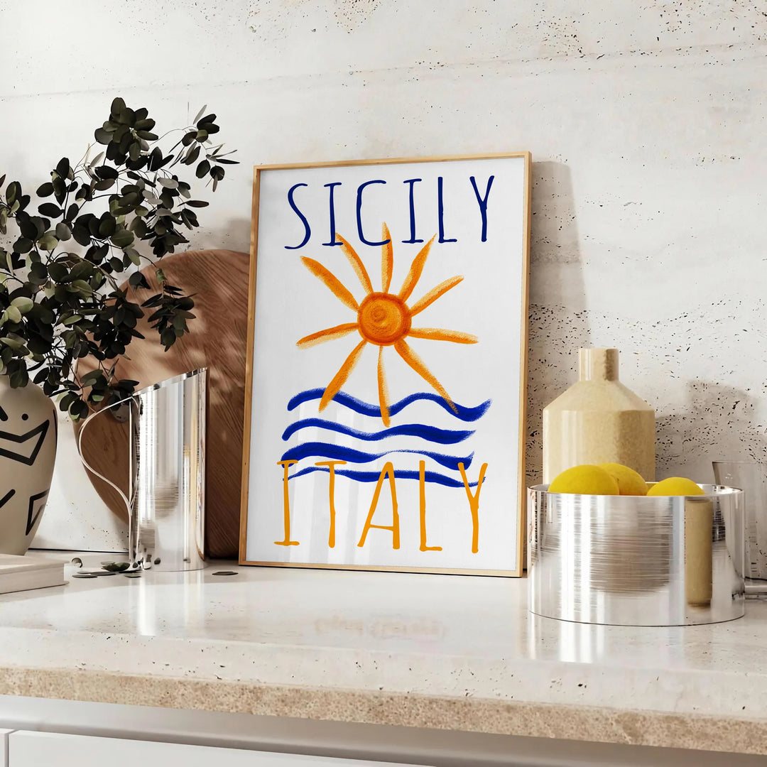 Vintage poster featuring Sicily, Italy with blue and orange hues - styled on a counter with eucalyptus and a bowl of lemons