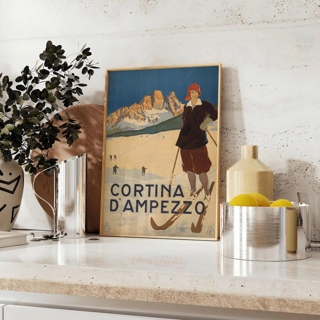 A ski scene with snow-covered mountains and pine trees in green and blue tones - styled on a counter with eucalyptus and a bowl of lemons