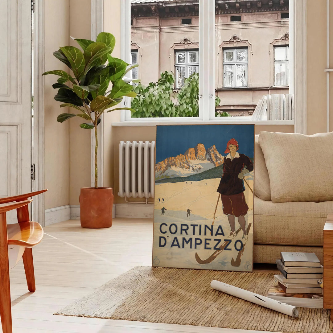 A ski scene with snow-covered mountains and pine trees in green and blue tones - in a Parisian living room with a sofa and a fig plant