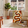 Midcentury-style illustration of a snake in orange and red tones - in a Parisian living room with a sofa and a fig plant
