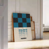 Abstract square shapes in black and brown tones - leaning on a herringbone floor against a white panelled wall
