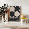 Abstract composition of squares and circles in black and brown tones - styled on a counter with eucalyptus and a bowl of lemons