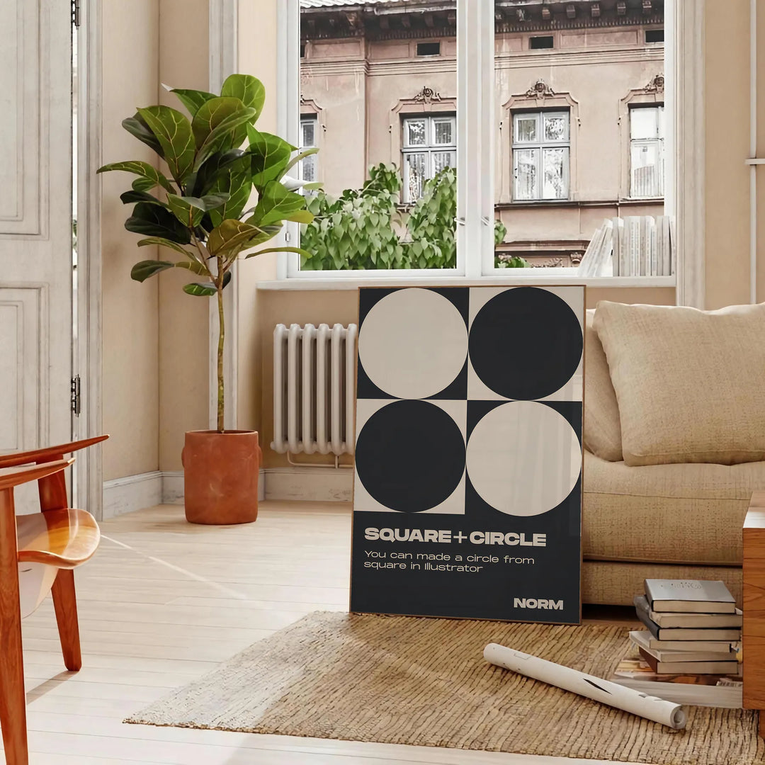 Abstract composition of squares and circles in black and brown tones - in a Parisian living room with a sofa and a fig plant