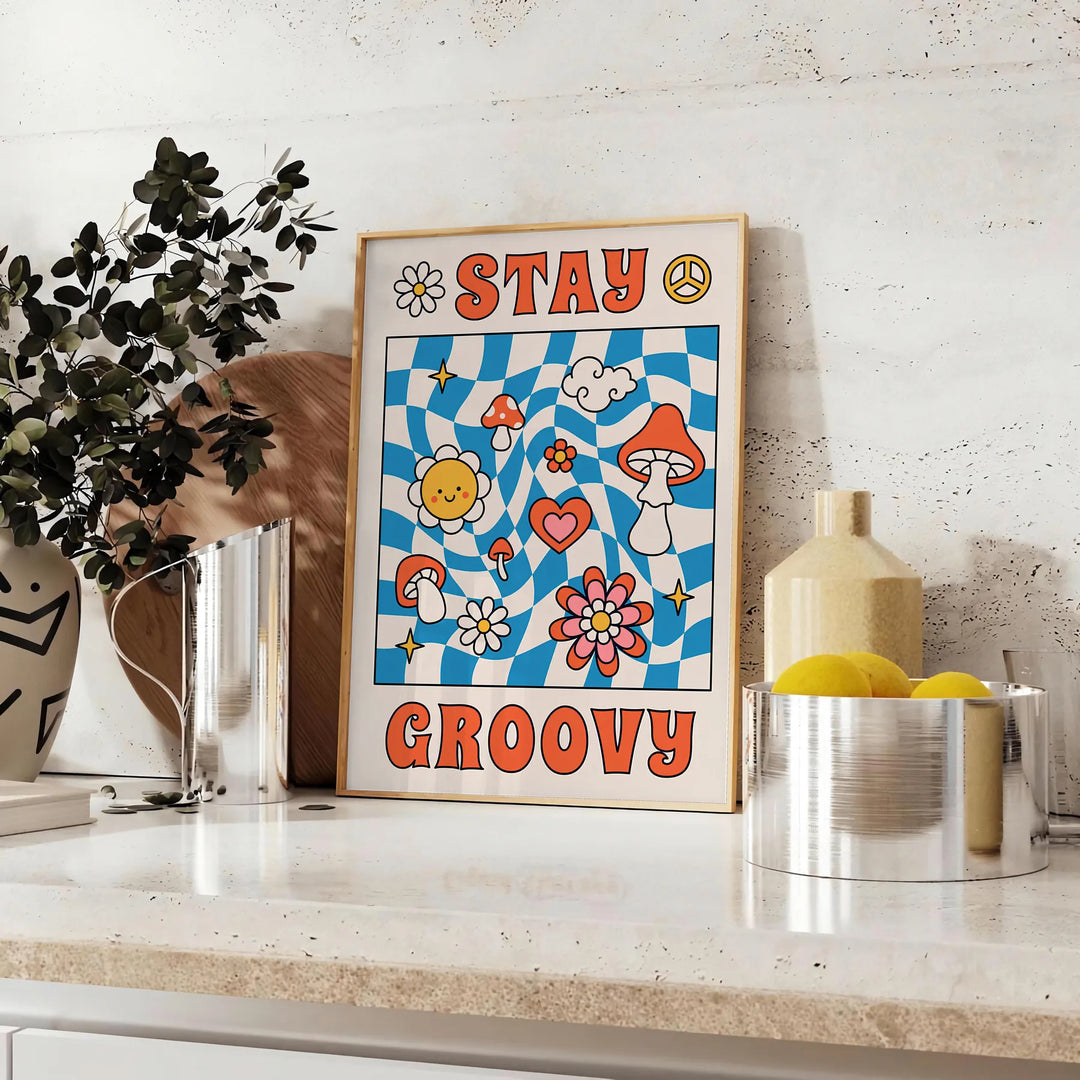 Pôster de estilo retrô com cores azul e laranja apresentando a frase 'Stay Groovy' - sobre uma bancada com eucalipto e uma taça de limões