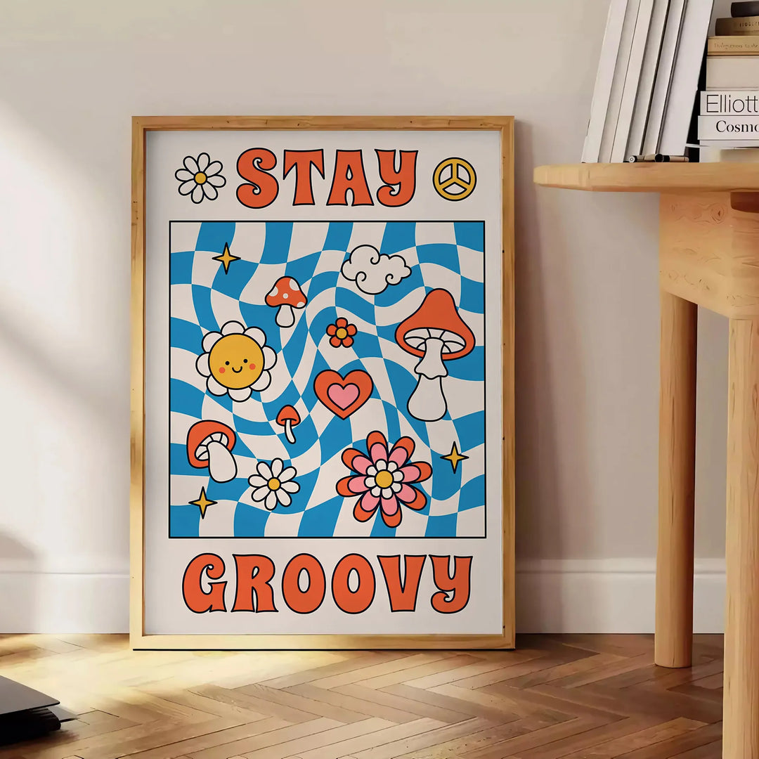 Pôster de estilo retrô com cores azul e laranja apresentando a frase 'Stay Groovy' - ao lado de uma mesa de apoio redonda em madeira com livros