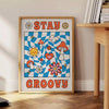 Pôster de estilo retrô com cores azul e laranja apresentando a frase 'Stay Groovy' - ao lado de uma mesa de apoio redonda em madeira com livros