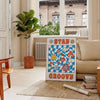 Pôster de estilo retrô com cores azul e laranja apresentando a frase 'Stay Groovy' - numa sala parisiense com sofá e um ficus