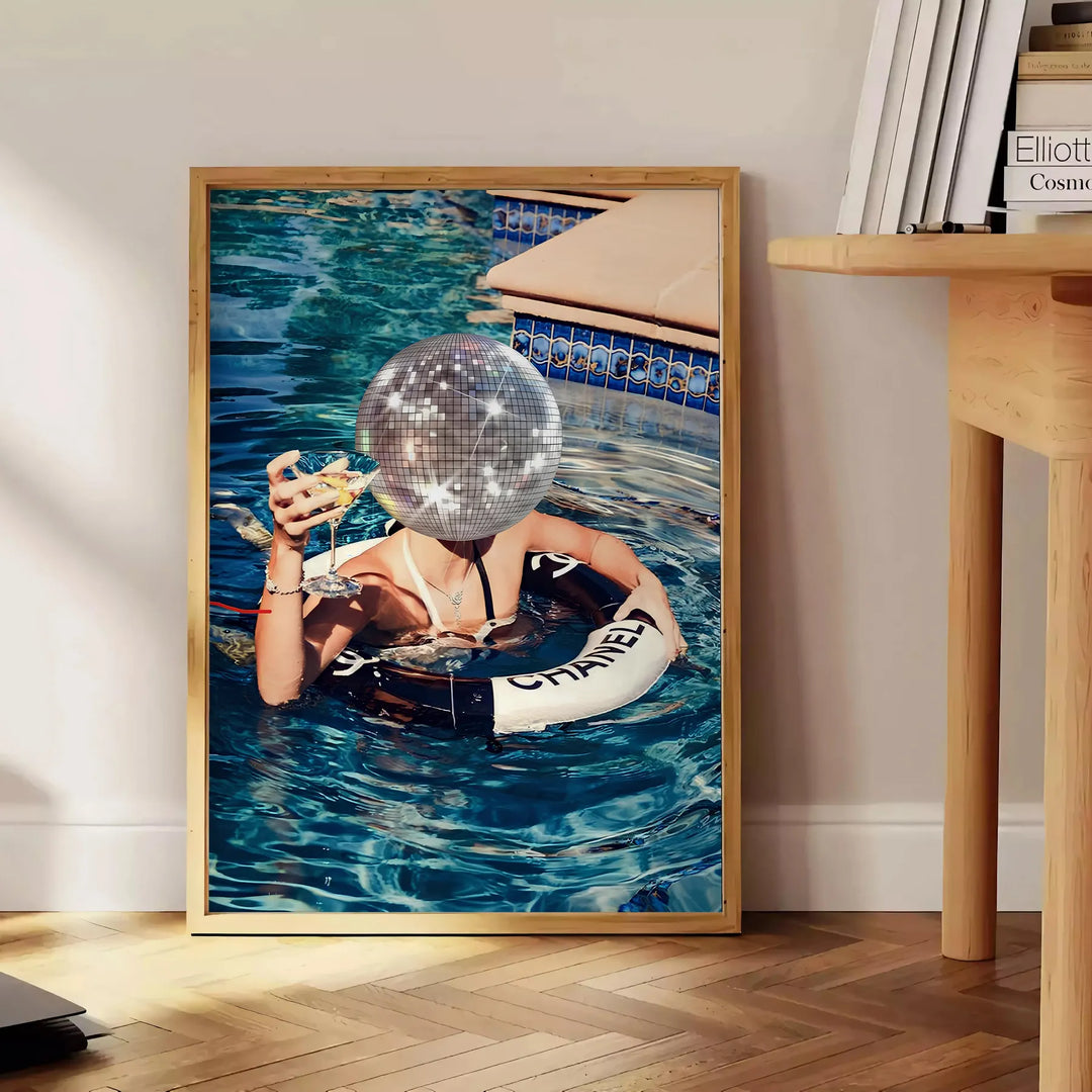 A stylized swimming pool scene with earthy browns and greens - beside a round wooden side table with books