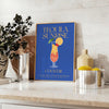 A colorful illustration of a Tequila Sunrise cocktail with orange and yellow hues. - styled on a counter with eucalyptus and a bowl of lemons