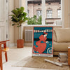 Travel poster featuring New York skyline with green and blue tones - in a Parisian living room with a sofa and a fig plant