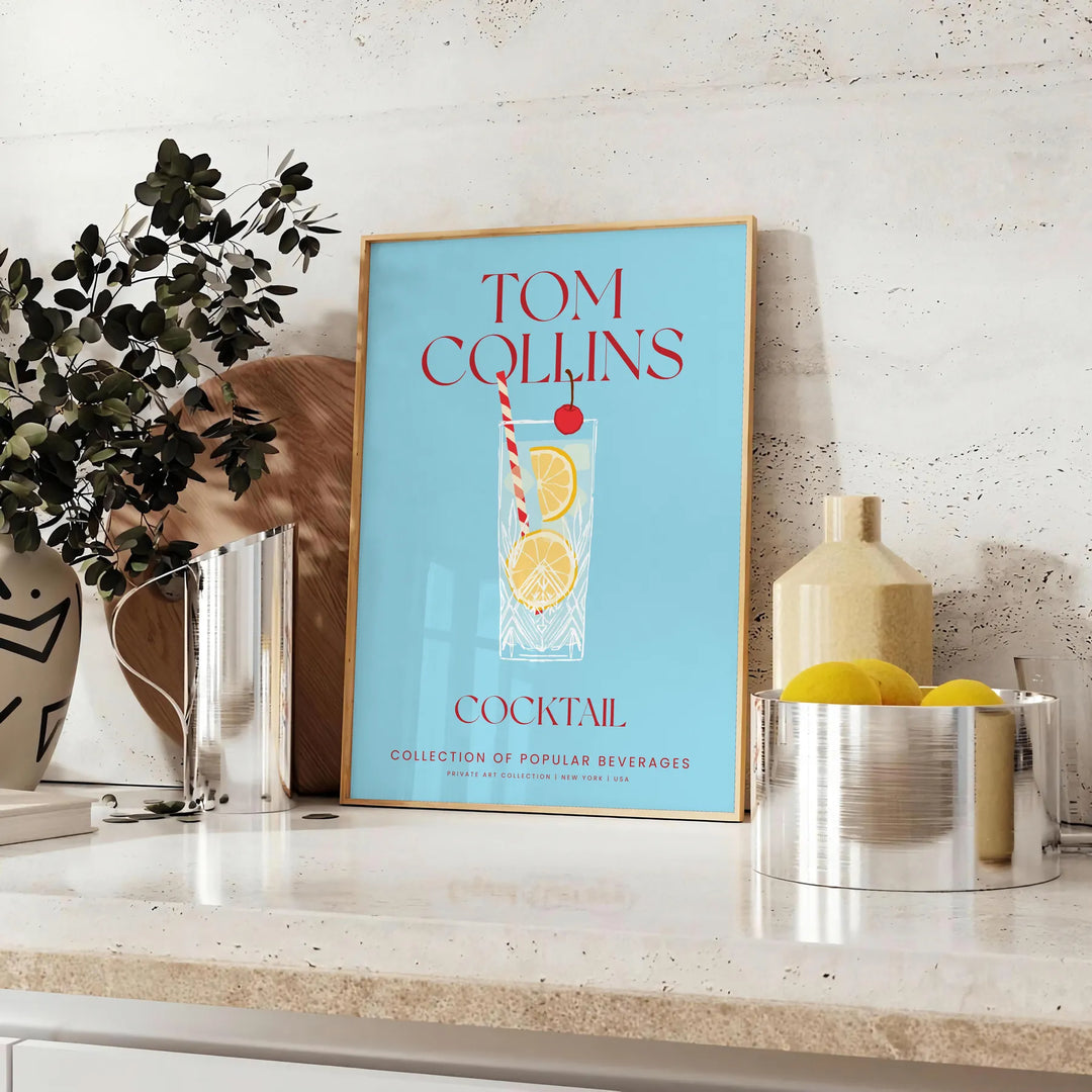 Illustration of a Tom Collins cocktail in a glass with lemon and cherry, yellow and blue colors - styled on a counter with eucalyptus and a bowl of lemons