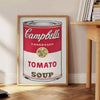 A colorful depiction of a tomato soup can with a vintage pub aesthetic - beside a round wooden side table with books