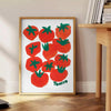 a colorful illustration of tomatoes on a blue background - beside a round wooden side table with books