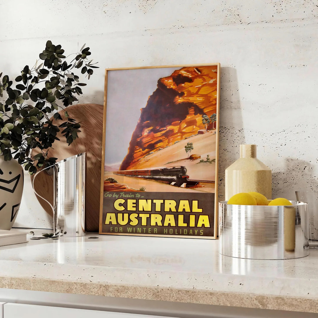 Illustration of a train traveling through lush Australian landscapes in green and blue tones - styled on a counter with eucalyptus and a bowl of lemons