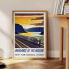 A vintage-style train travel poster featuring a gray and blue color palette - beside a round wooden side table with books
