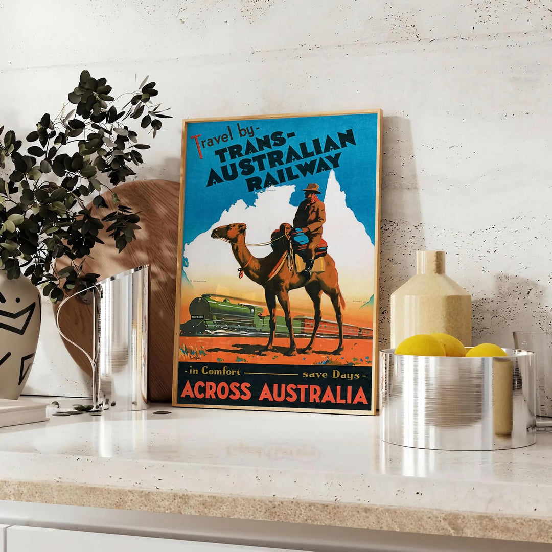 A vintage travel poster featuring a stylized landscape of Australia in black and blue tones - styled on a counter with eucalyptus and a bowl of lemons