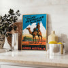 A vintage travel poster featuring a stylized landscape of Australia in black and blue tones - styled on a counter with eucalyptus and a bowl of lemons