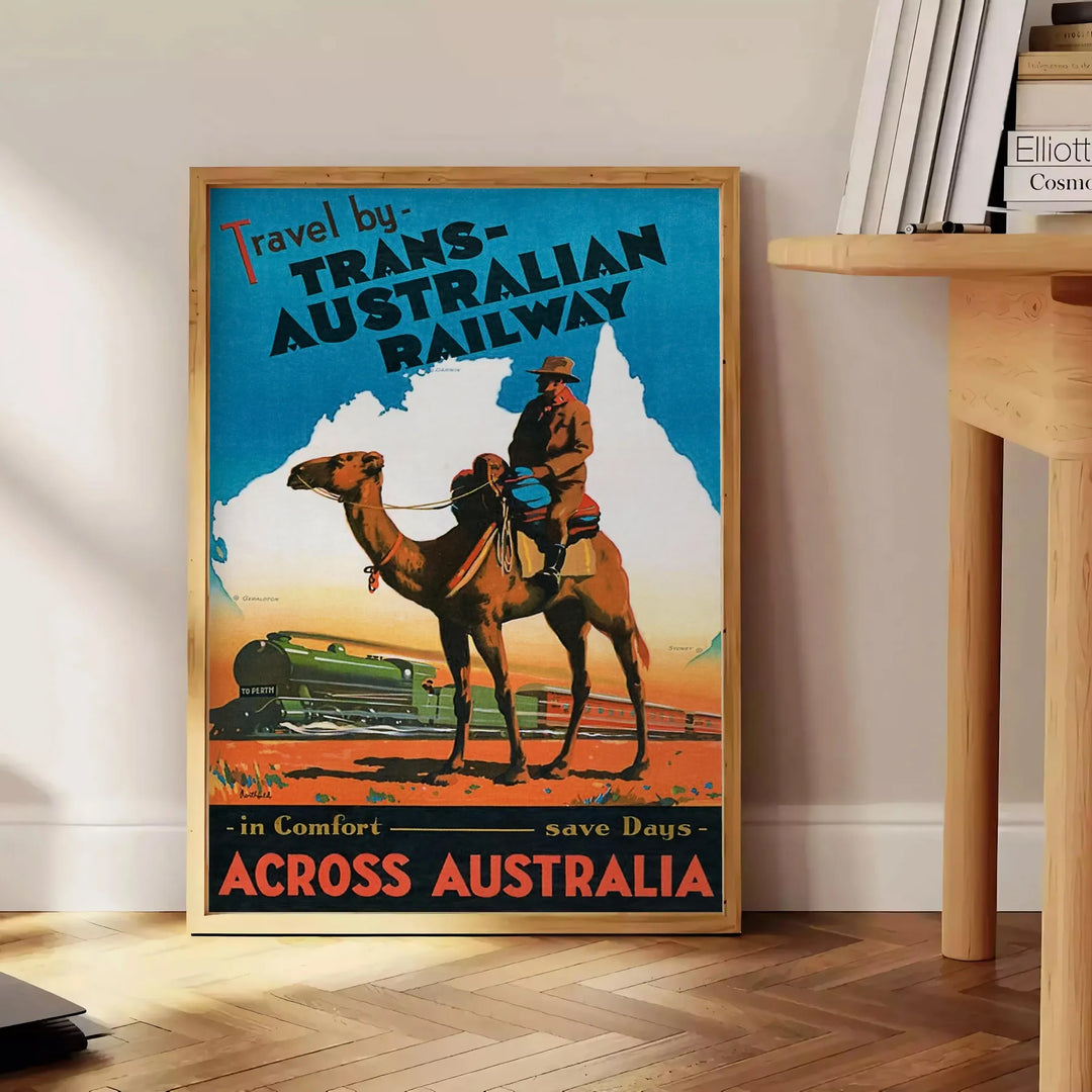 A vintage travel poster featuring a stylized landscape of Australia in black and blue tones - beside a round wooden side table with books