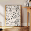 A modern poster featuring a sleek design in gray and black tones - beside a round wooden side table with books