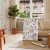 A modern poster featuring a sleek design in gray and black tones - in a Parisian living room with a sofa and a fig plant
