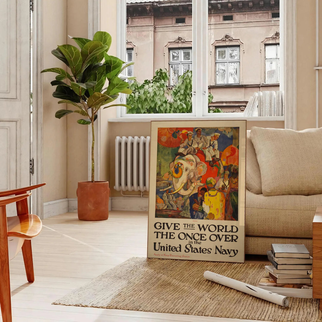 United States Navy travel poster featuring a ship in blue and red tones - in a Parisian living room with a sofa and a fig plant