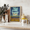 Vintage travel poster featuring the Venice Simplon train with orange and green hues - styled on a counter with eucalyptus and a bowl of lemons